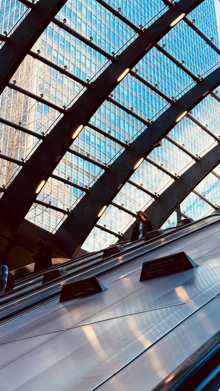 View of an escalator in London with striking architecture and skyscrapers in the background.