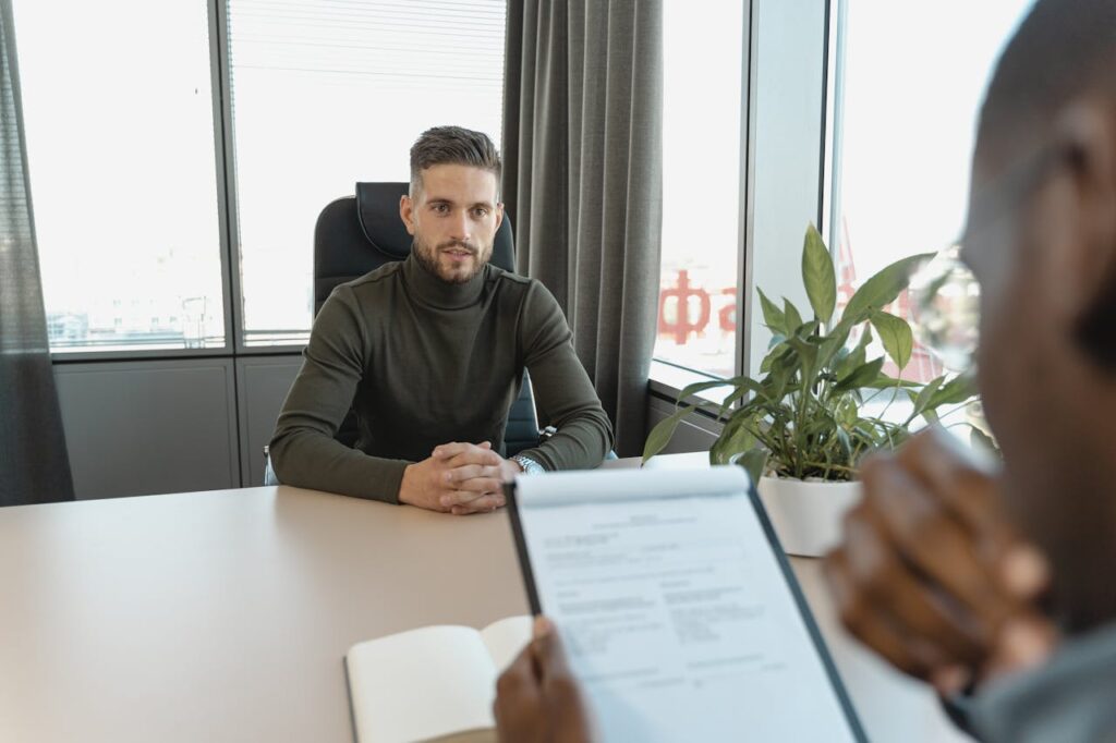 Crafting Captivating Headlines: Your awesome post title goes here Professional man in turtleneck at office desk during an interview.