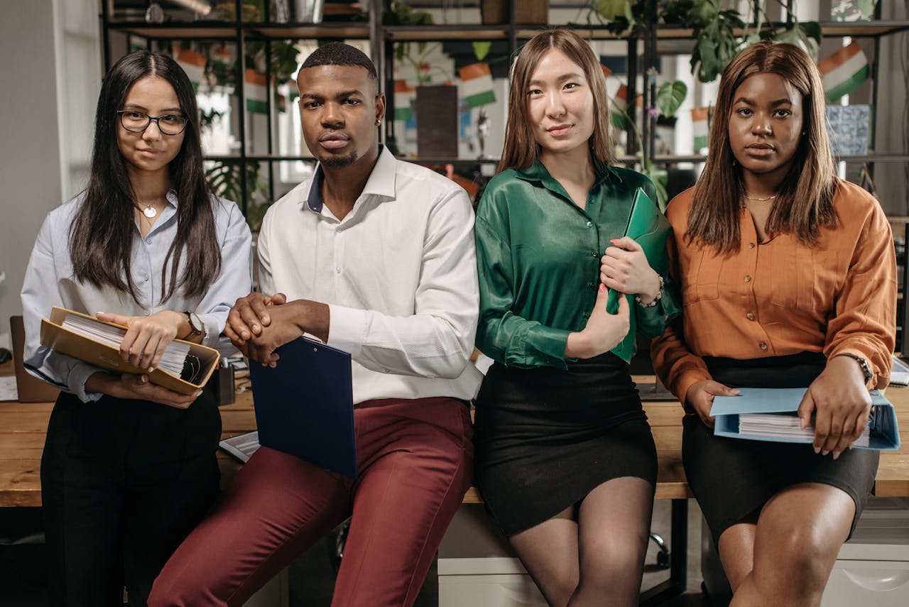 A diverse group of young professionals posing confidently in an office environment.